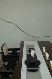 A modern tea room featuring minimalist furniture, wooden table, and white accessories.