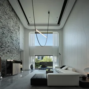 Modern living room with marble accents, high-ceiling, and large windows.