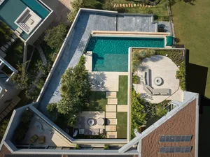 A modern pool with concrete and glass materials.