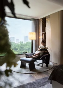 A woman relaxing on a modern leather chaise lounge in a serene setting