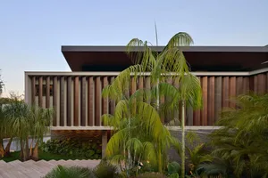 The exterior of a modern residential building featuring a wooden façade and a sloping roof.