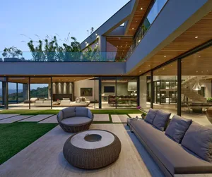 Modern residential outdoor space featuring concrete, glass, and metal elements and furniture.