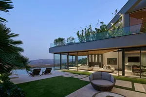 A modern residential outdoor space featuring glass and steel materials, with a focus on the sleek, contemporary design and op