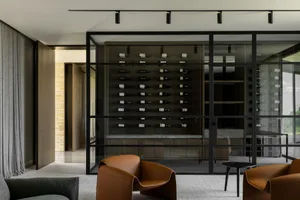 A contemporary wine cellar with a metal frame and glass door, showcasing an organized bottle collection.