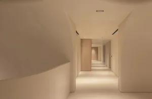 A minimalist corridor with concrete walls and floors, featuring clean lines and simple design elements.