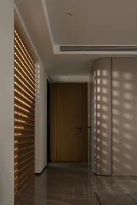 A modern corridor featuring a wooden panel wall and light wood flooring with a patterned lighting effect.
