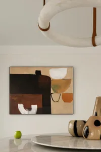 Modern abstract painting featuring geometric shapes and warm tones on a wall.