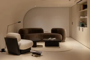 Modern living room with a brown velvet couch and a circular coffee table on a circular rug.