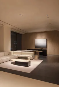Modern minimalist living room with neutral-tones leather furniture and a large screen TV on the wall.