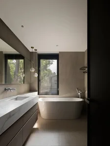 Modern minimalist bathroom featuring a freestanding bathtub with concrete walls and a glass window.