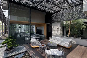 Modern, minimalist outdoor patio area with a wooden deck, white furniture, and potted plants.