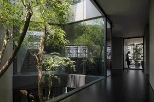 A sleek, minimalist interior design featuring a modern living room with stone accents and glass walls.