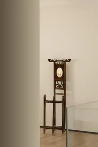 An antique wooden cloakroom rack with intricate carvings and a mirror in the center.