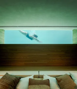 An empty swimming pool view through a window with a minimalist design setting.