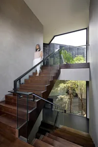 A modern staircase with wooden steps and glass railings inside a building