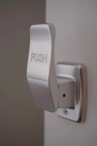 Silver metallic push button handle with the word 'PUSH' engraved on it