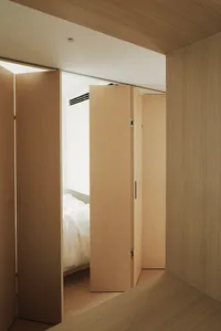 A minimalist bedroom with a wooden platform bed