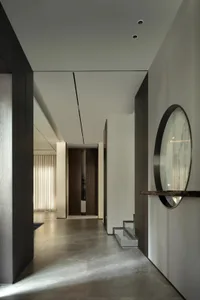 A modern entrance hallway with minimalist design elements, featuring concrete flooring and clean lines.