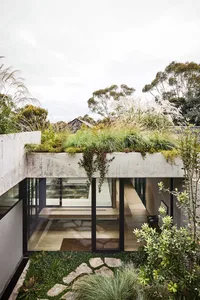 Modern residential home with concrete, glass, and natural stone materials