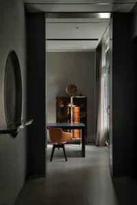 Modern home office with metallic finishes, featuring a sleek desk and minimalist chair.