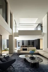A modern living room with concrete, glass, and metal finishes.