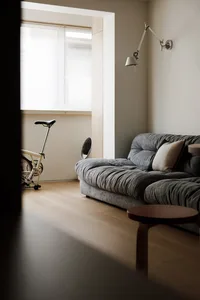 A modern living room featuring a gray sofa and wooden table.