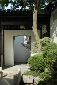 A traditional Chinese garden featuring stone pathways and wooden elements.