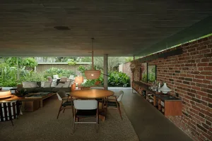 Industrial style living room with concrete ceiling, brick wall, and furniture.