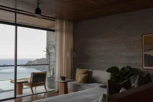A minimalist bedroom featuring concrete, wood, and glass materials.