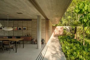 A modern interior design featuring concrete, brick, and wooden elements with outdoor access.