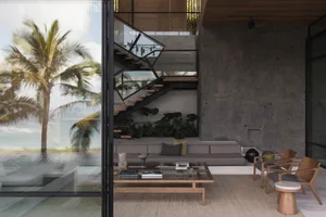 Modern living room with concrete and glass design elements, featuring a couch, chairs, and a coffee table.