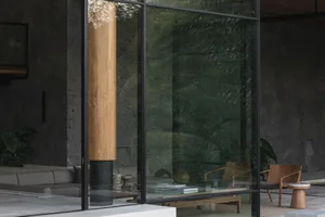 Modern lounge area featuring glass walls and concrete elements.