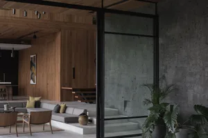 A modern living room with concrete walls, earth-toned furnishings, and minimalist decor.