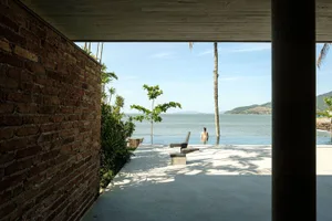 A modern poolside area with concrete elements and lush greenery.