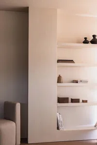 Minimalist interior design featuring white bookshelves and concrete materials.