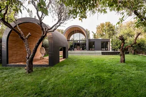 A modern backyard featuring wooden structures and glass windows.
