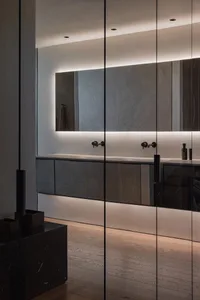 Modern bathroom interior featuring concrete countertops, glass wall, and wooden floor.