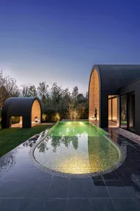 a modern residential swimming pool with glass mosaic tiles and illuminated interior