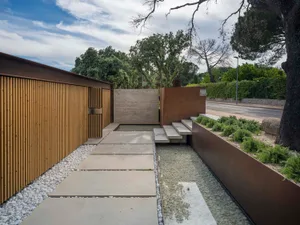 A modern landscape design featuring concrete elements and a minimalist approach.