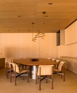 A modern dining room featuring a wooden table and chairs, with a wooden ceiling and walls