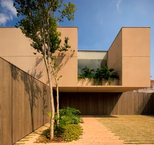 Modern residential exterior featuring sandstone and glass materials.