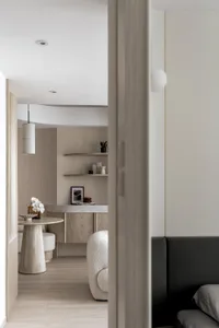 Minimalist apartment interior with wooden flooring, concrete countertops, and plush seating.