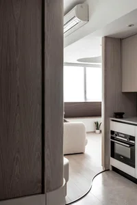 Modern minimalist kitchen featuring sleek, contemporary wood finishes and a clean, uncluttered design.