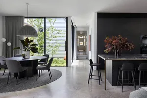 A modern living space featuring a concrete floor, dark wood furniture, and marble countertops.