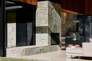 Modern, minimalist outdoor living space featuring stone, concrete, and metal materials.