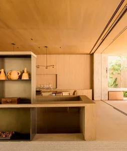A modern minimalist kitchen interior with wooden finishes and a sleek, open layout.