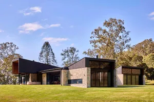 Modern residential house featuring stone and glass materials.