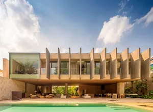 A modern residential interior featuring concrete, glass, and wood materials.