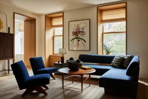 Modern living room featuring wooden furniture, a blue couch, and a coffee table with decorative items.