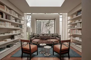A modern living room with bookshelves, comfortable seating, and a cozy atmosphere.